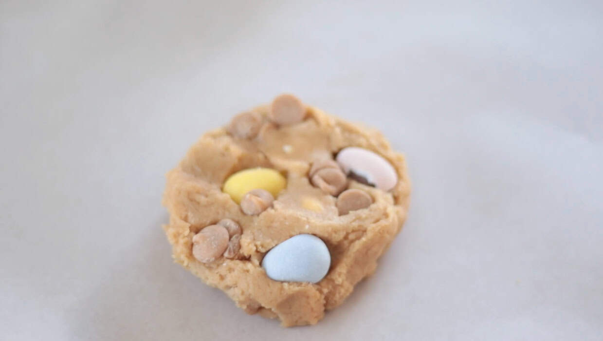 Scoop of peanut butter cookie dough with peanut butter chips and cadburry eggs.
