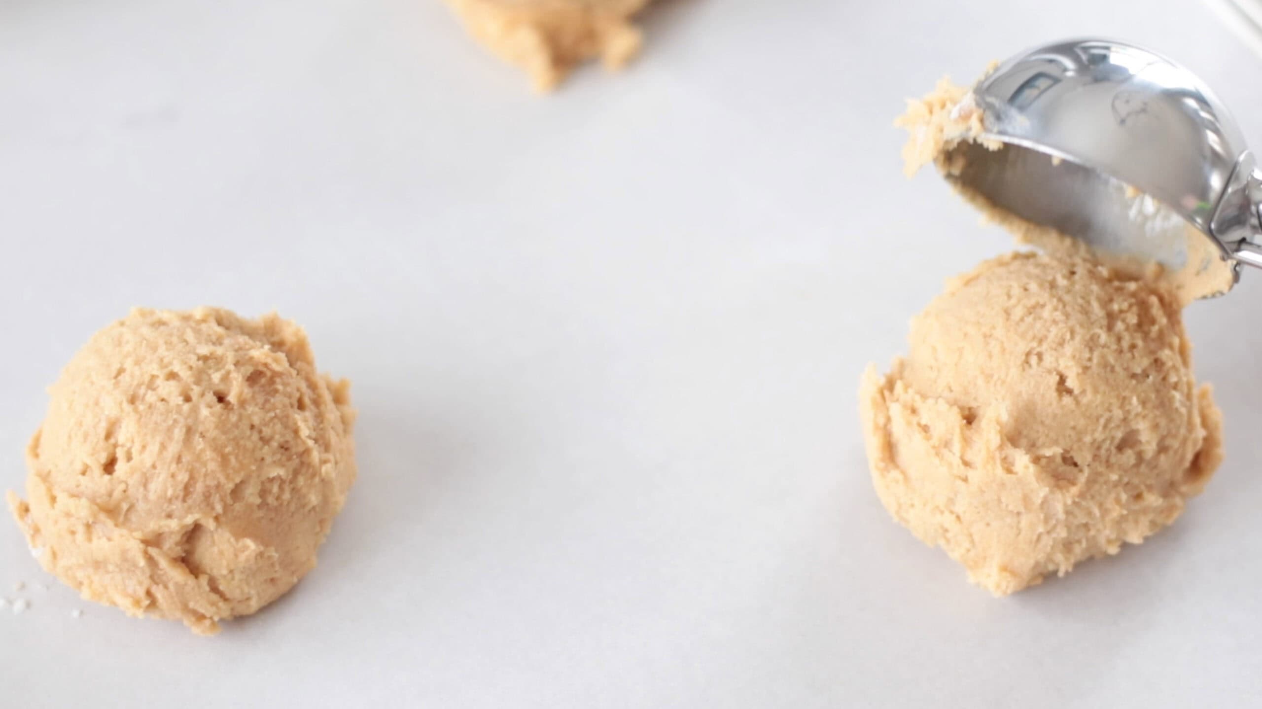 Balls of cookie dough on baking sheet.