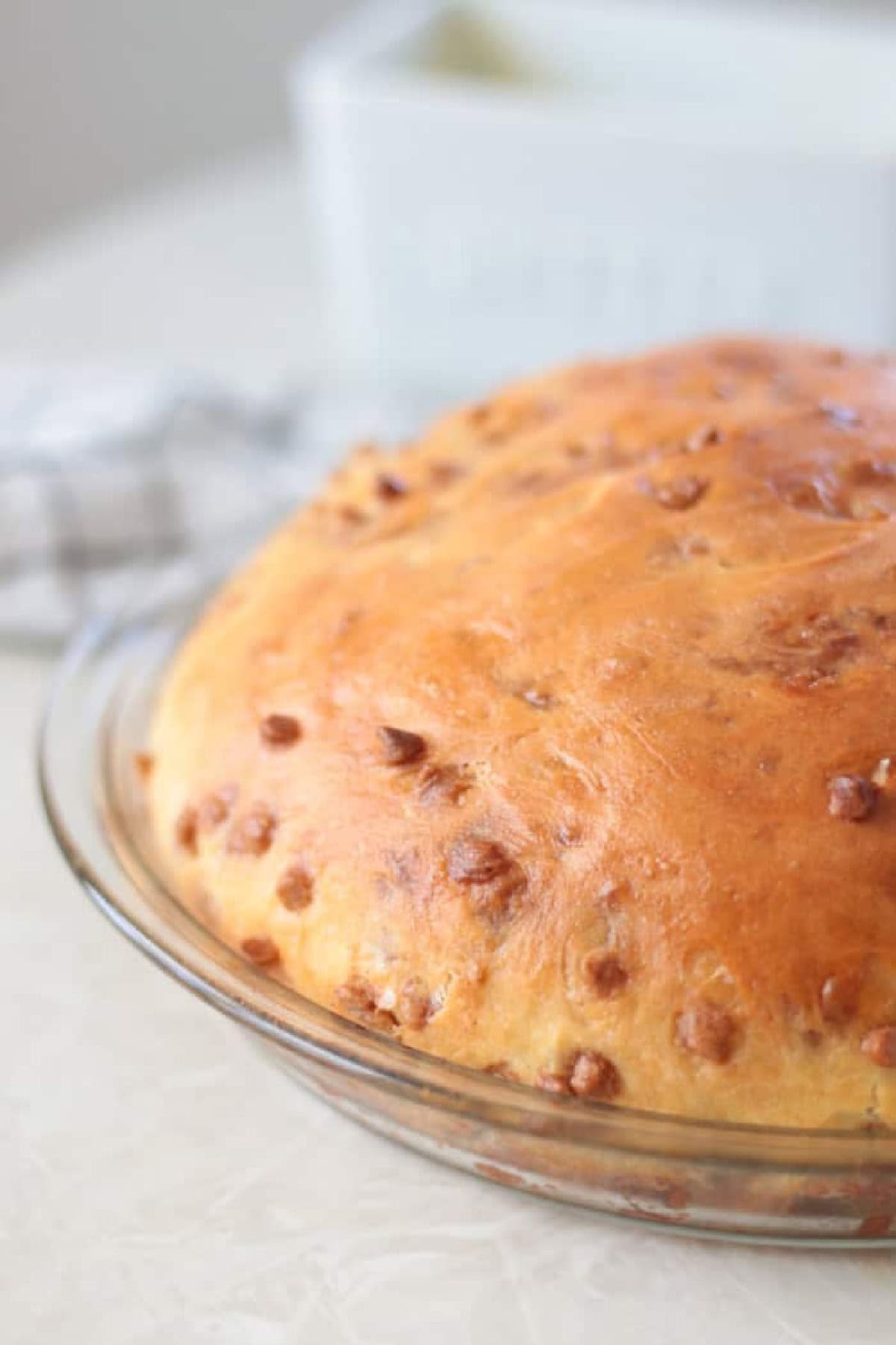 Loaf of cinnamon chip bread in pie pan.