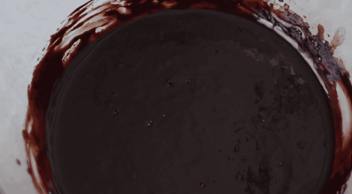 Cocoa powder and melted butter mixed together in bowl.