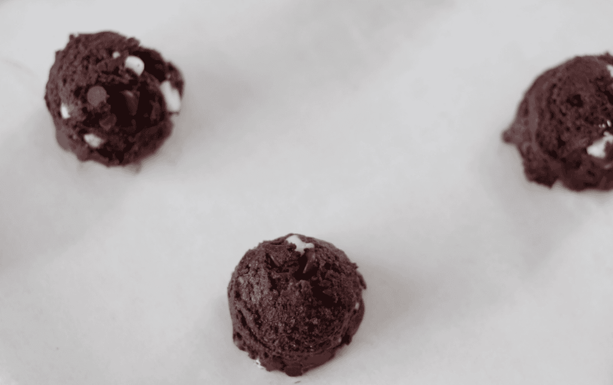 Cookie dough balls on baking sheet with parchment paper.