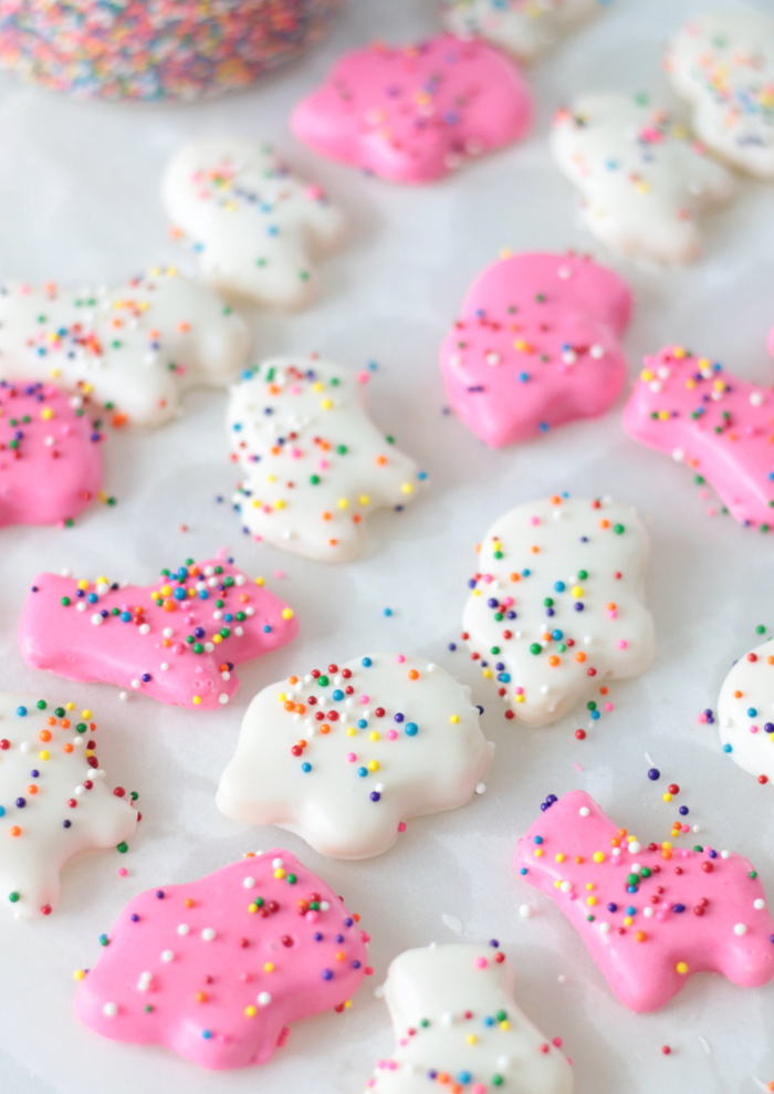 pink and white circus animal cookies on parchment paper