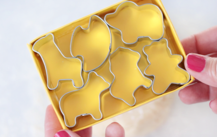 hand holding box of small animal cookie cutters