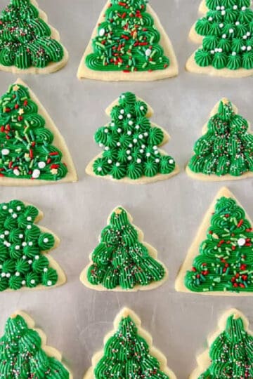 Frosted green tree cookies on baking sheet.