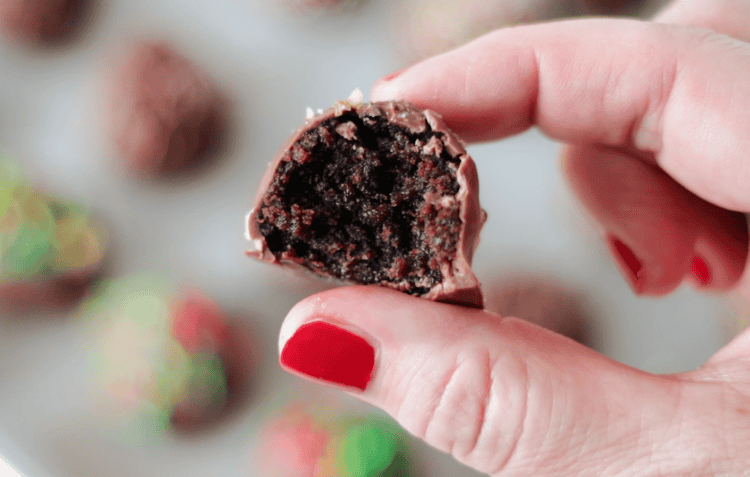 hand holding truffle with bite taken from it