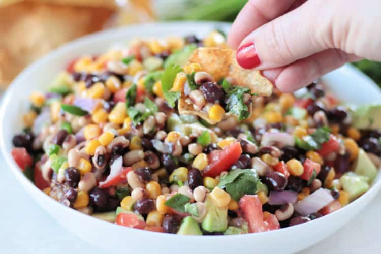 hand dipping chip into cowboy caviar