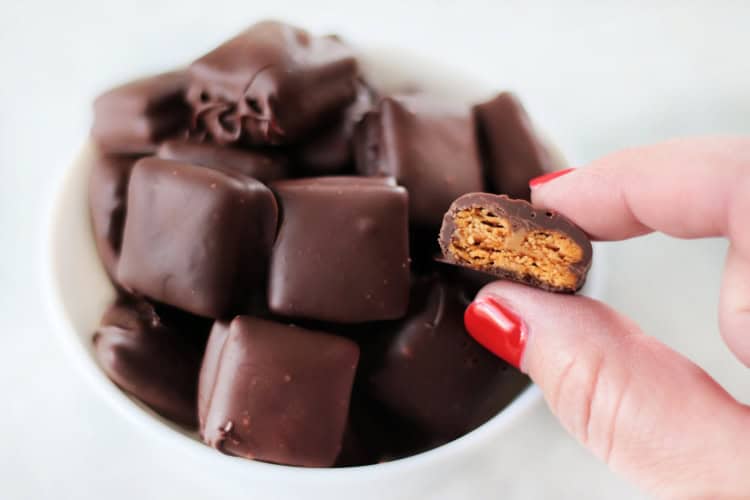 hand holding half of a cheez its peanut butter bite