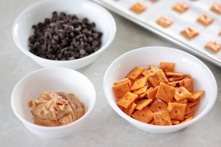 bowl of peanut butter, bowl of chocolate chips and bowl of cheez its