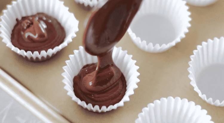spooning chocolate into mini cupcake liner