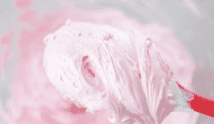 rubber spatula with pink marshmallow frosting on it