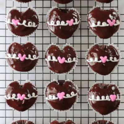 cooling rack with 15 hostess heart cupcakes on it