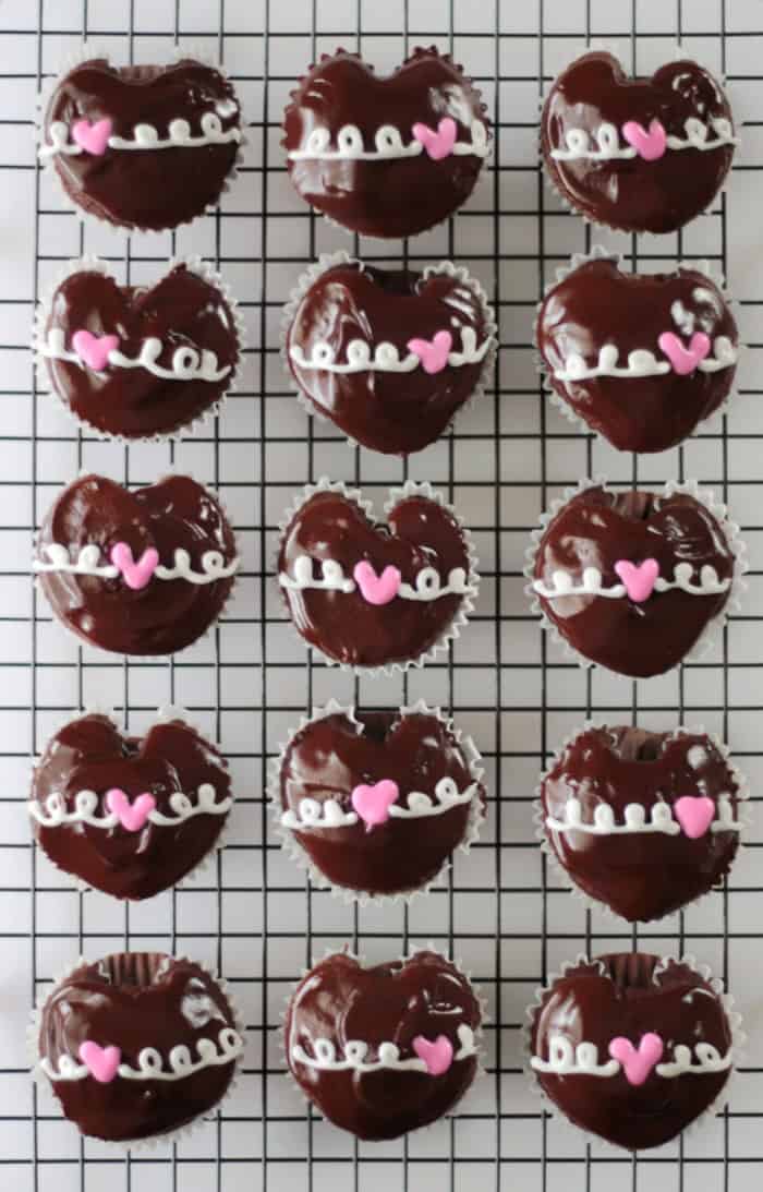 cooling rack with 15 hostess heart cupcakes on it
