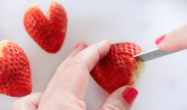 knive cutting v-shape from strawberry