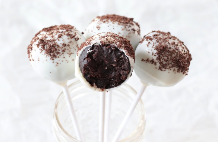 4 cookies and cream cake pops in jar, one with bite taken out of it