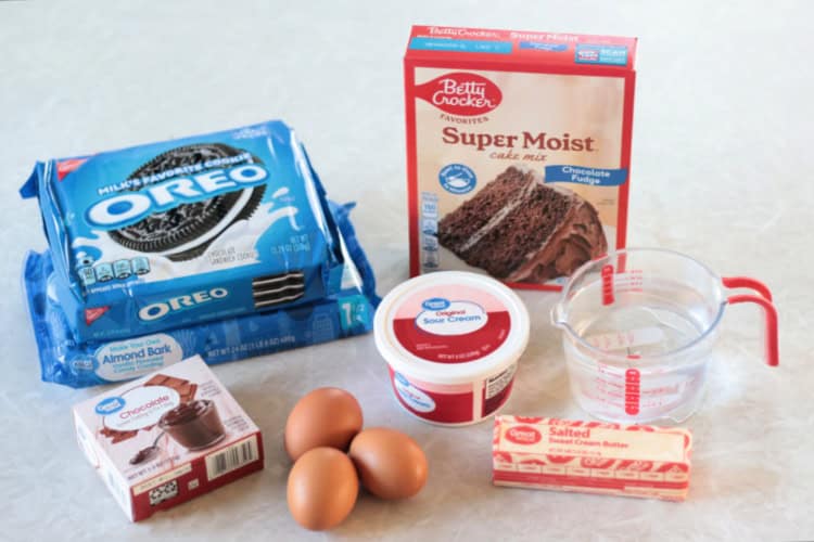 almond bark, oreos, box of cake mix, box of pudding mix, 3 eggs, stick of butter, container of sour cream and cup of water