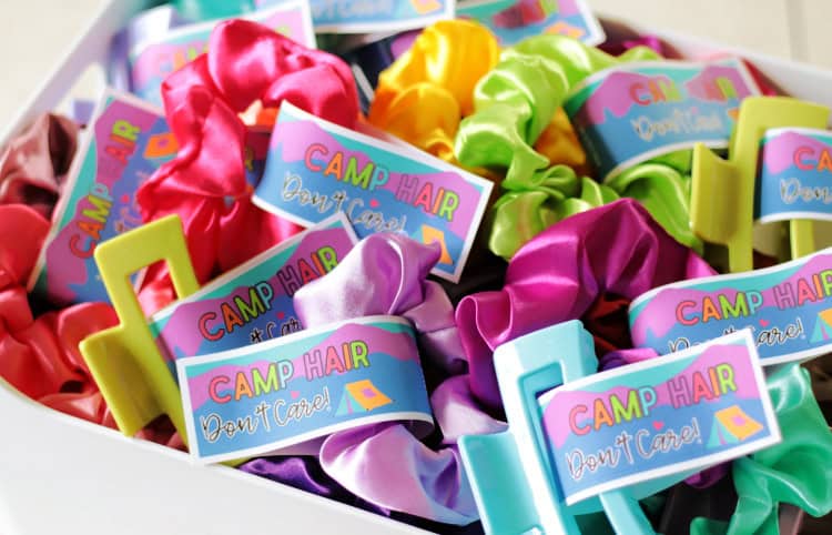 white container full of hair clips and scrunchies with summer camp tags