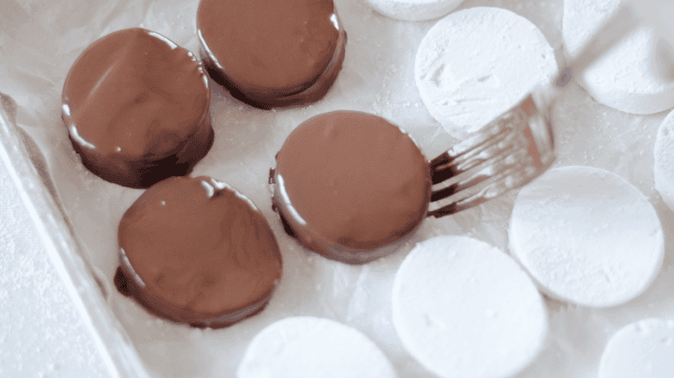 fork sliding dipped eggs onto baking sheet