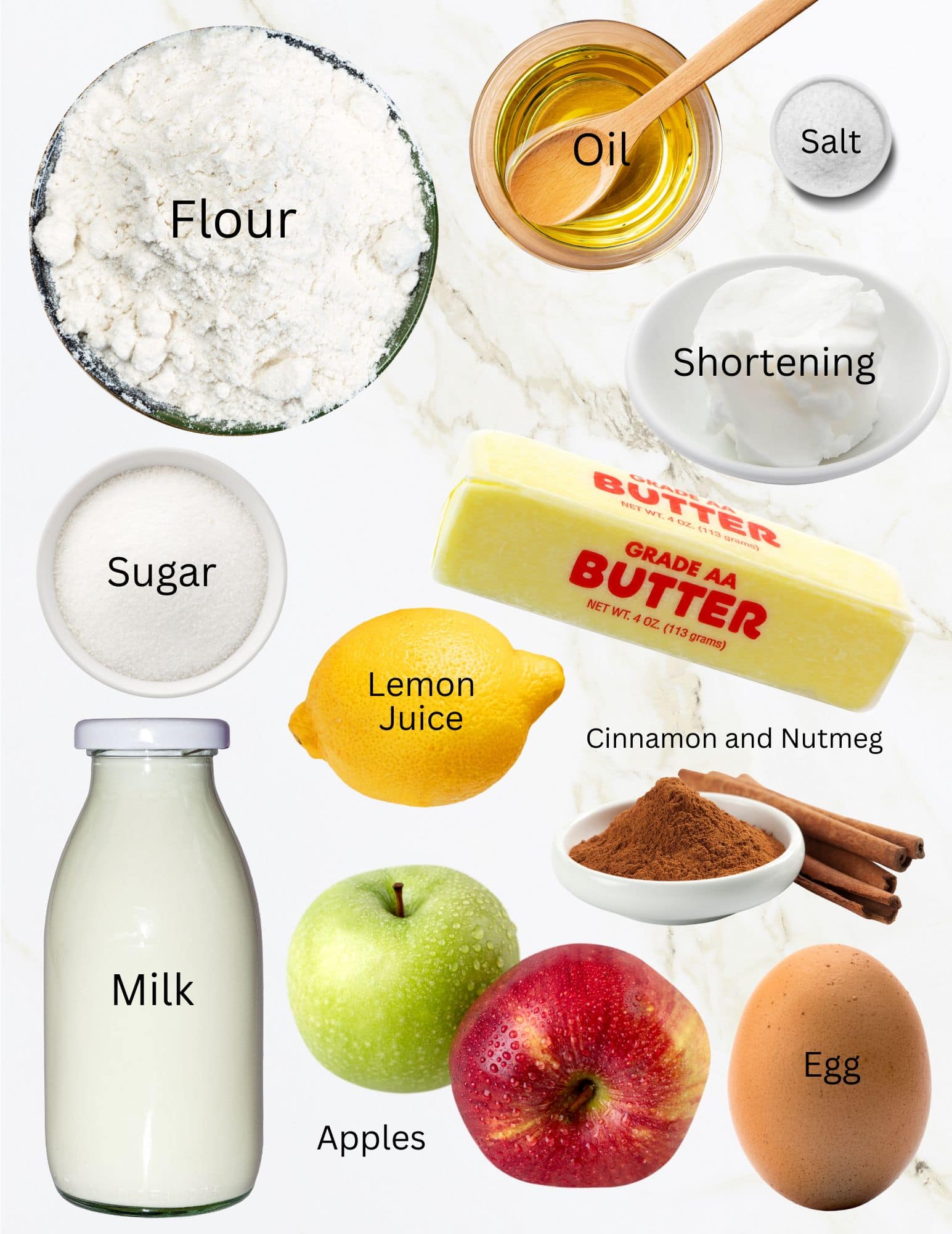 Bowls of flour, oil, salt, sugar, shortening, cinnamon, two apples, an egg, stick of butter, lemon and bottle of milk.