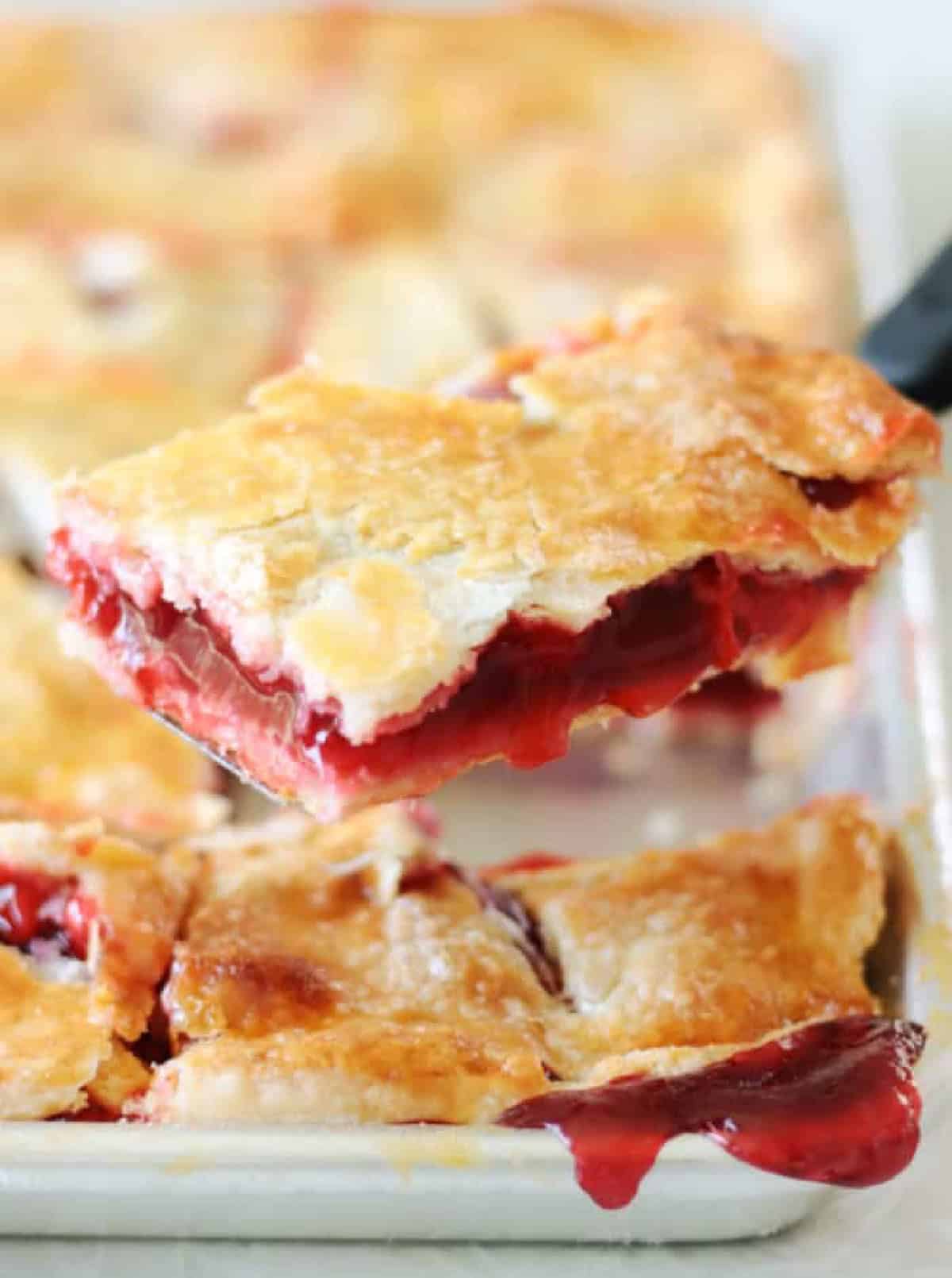 Slice of cherry pie on a metal spatula.