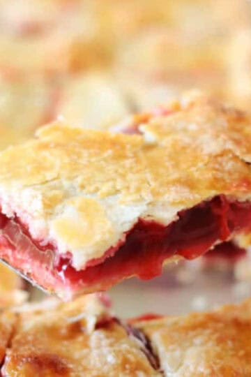 Slice of cherry slab pie on metal spatula.