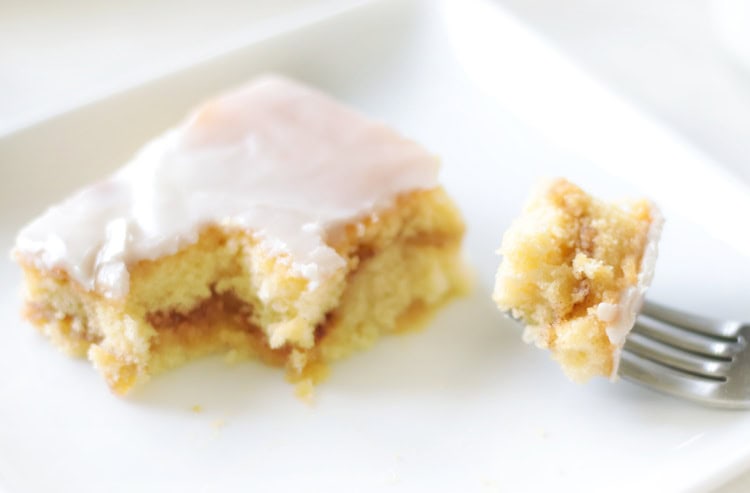 slice of cake and fork with bite of honey bun cake on it.