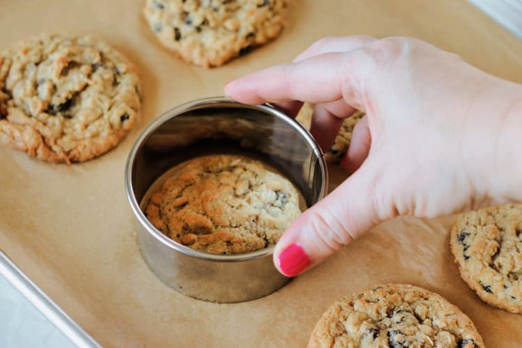 hand shaping cookies with large cookie cutter