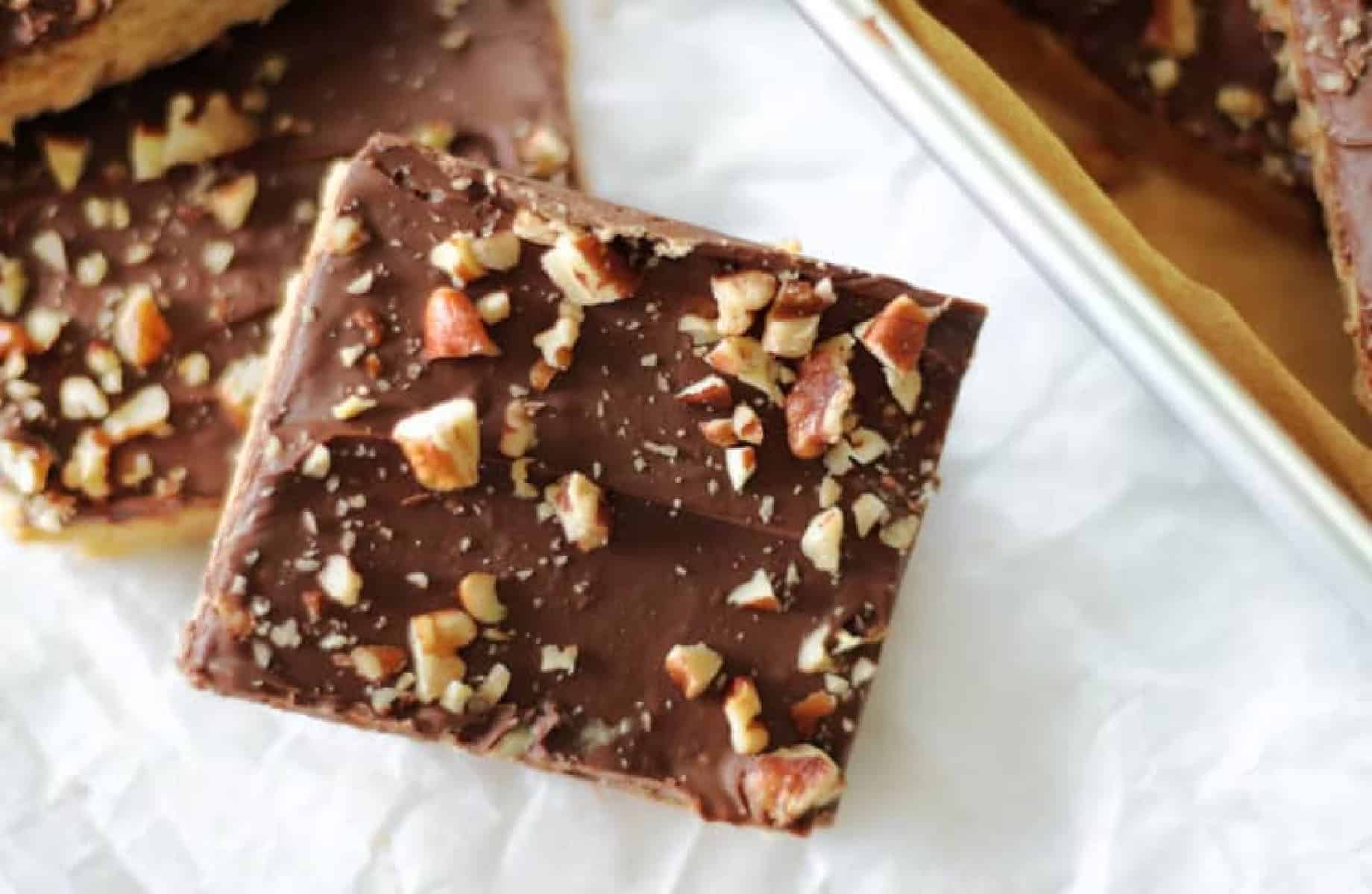 Two toffee bar squares cut and set on parchment paper.