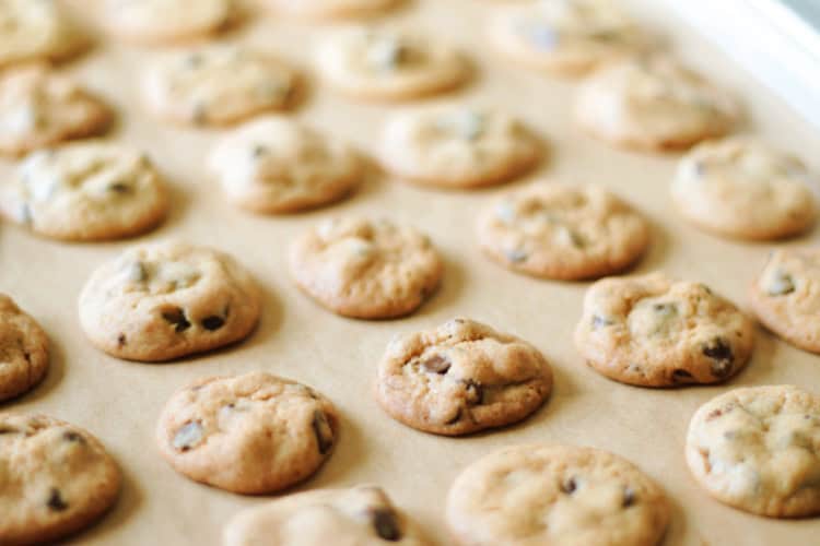baking sheet with parchment paper and batch of copycat famous amos chocolate chip cookies