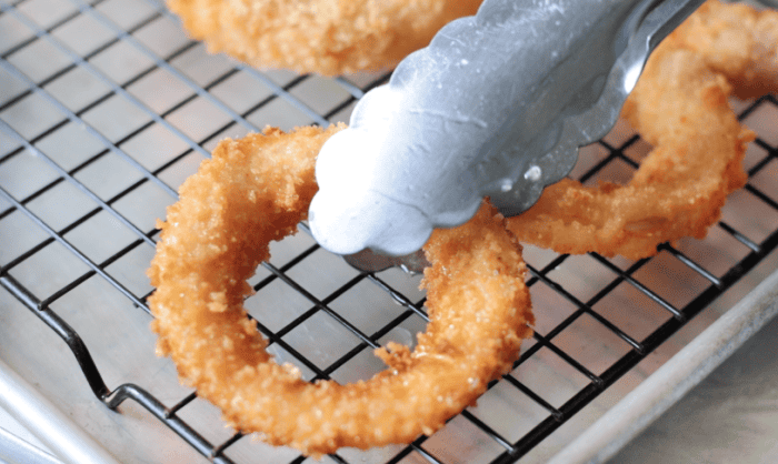 A person holding a metal spatula.