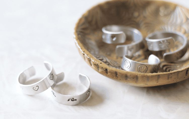 ring bowl with 3 rings inside and 2 sitting next to it