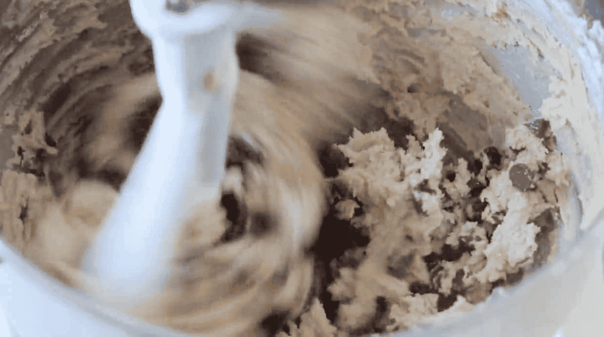 Metal mixing bowl with chocolate chip cookie dough.