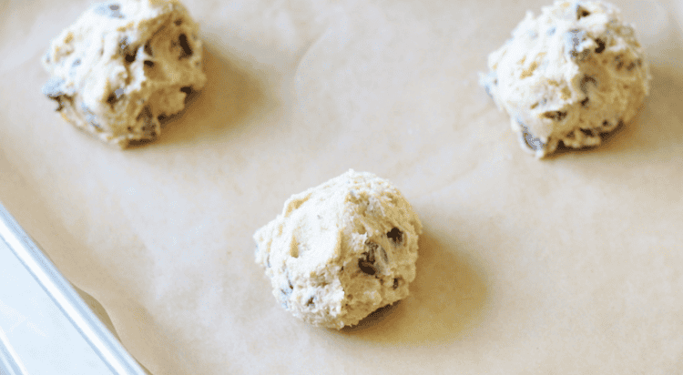balls of cookie dough on baking sheet with parchment paper