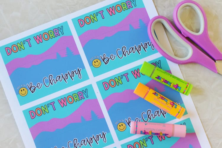 sheet of chapstick printable tags with scissors and 3 tubes of lip balm