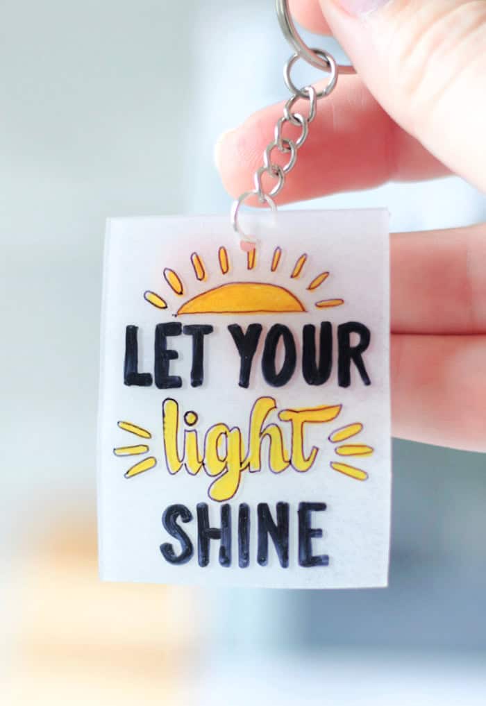 shrinky dink keychain with "let your light shine" phrase on the front