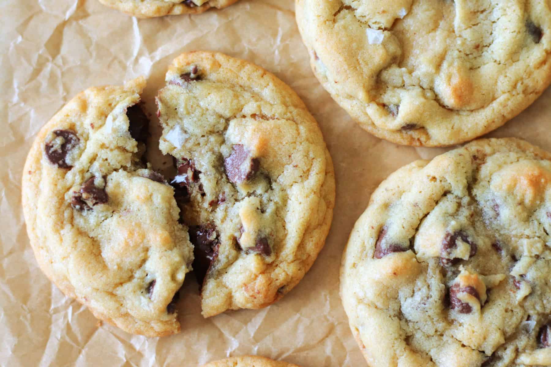 chocolate chip cookie broken in half on parchment paper