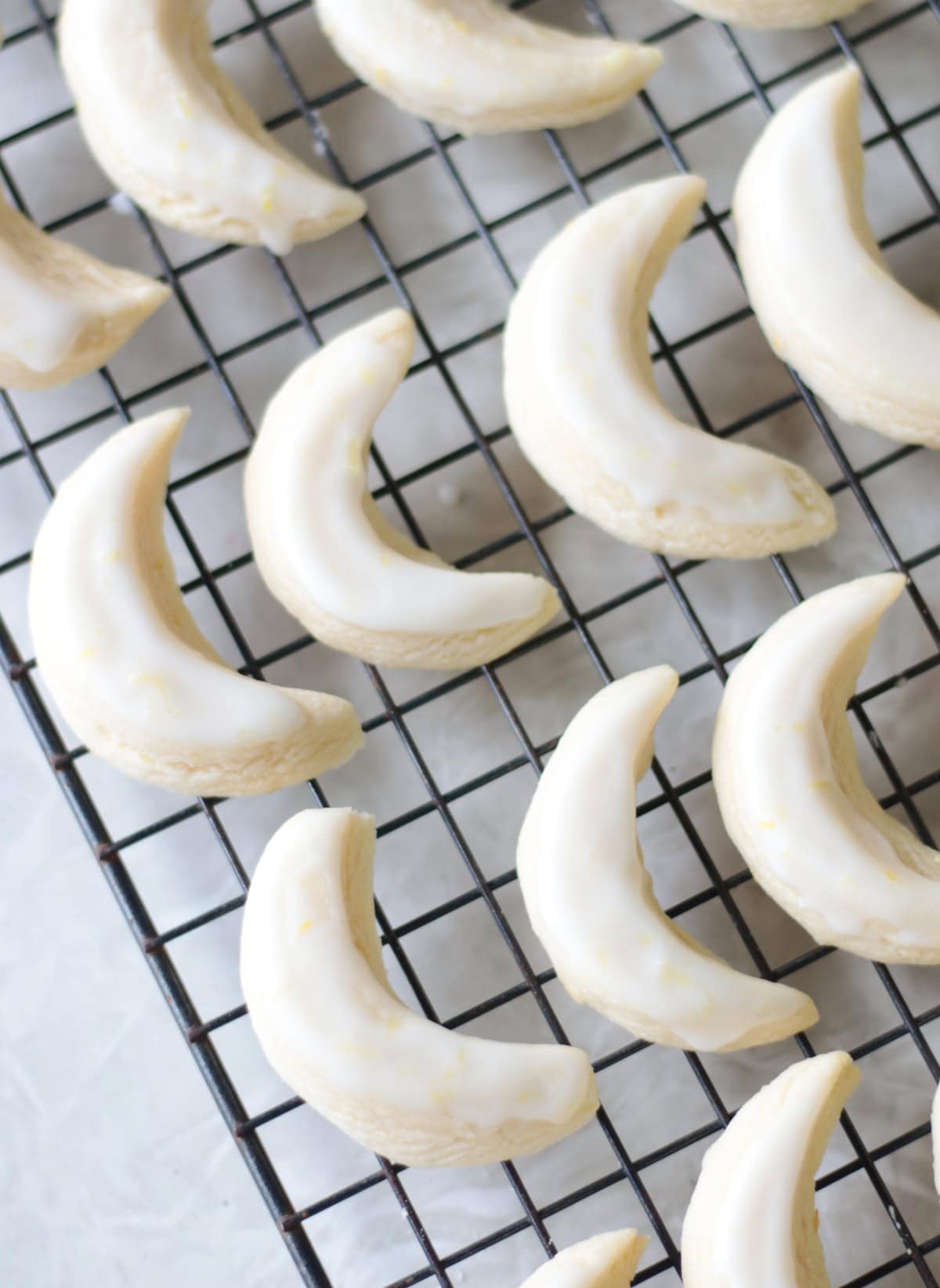 Wire cooling rack with lemon crescent cookies.