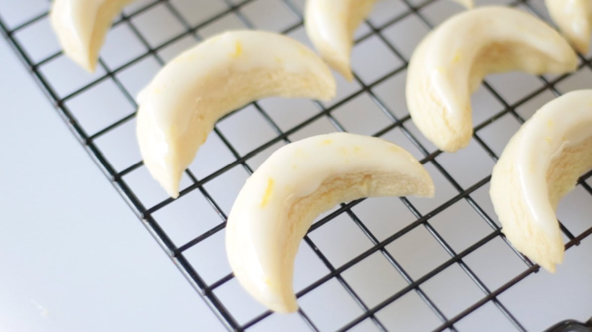 Glazed lemon cookies on wire cooling rack.