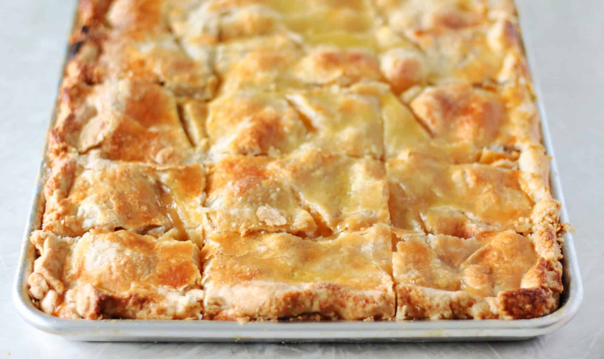 Sheet pan of peach slab pie, freshly baked.