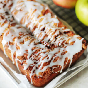 Apple fritter bread with glaze drizzled over top.