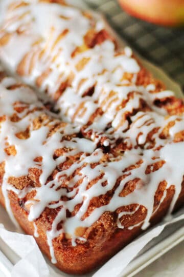 Apple fritter bread with glaze drizzled over top.