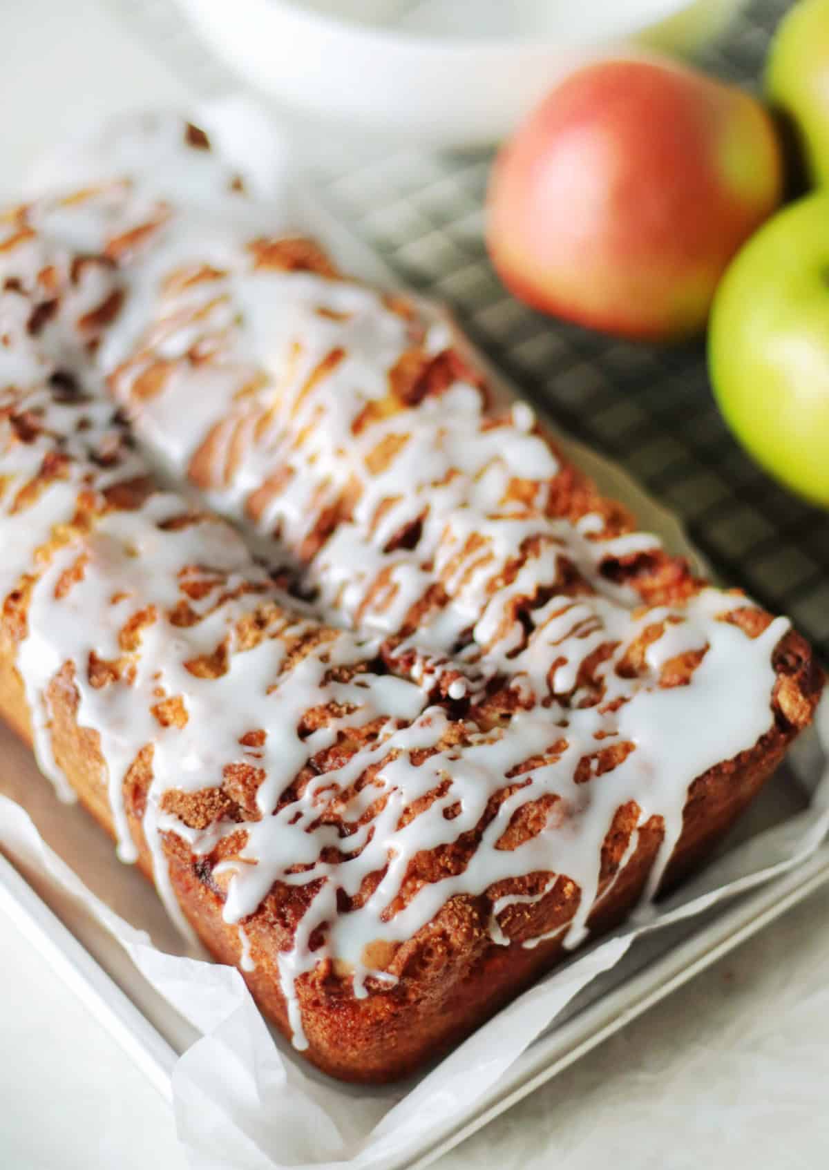 Loaf of apple fritter bread on baking tray.