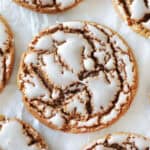 Iced molasses cookies on parchment paper.