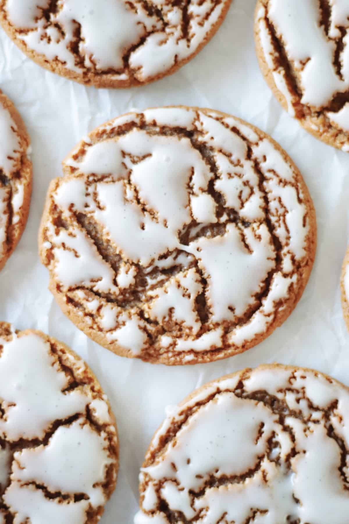 Iced molasses cookies on parchment paper.