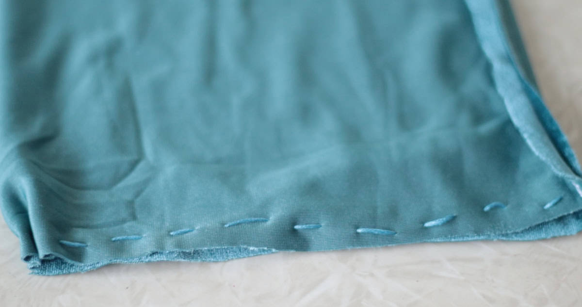 Gathering stitches on bottom of blue velvet fabric.