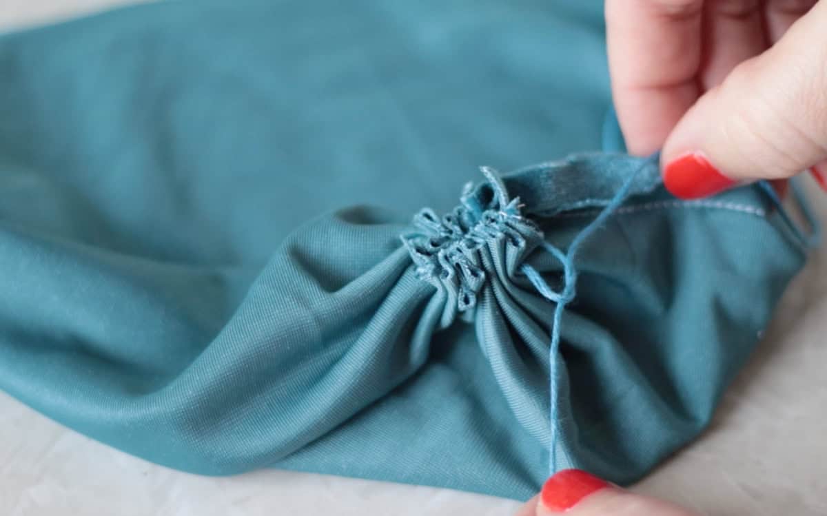 Hand pulling strings to tie a not.