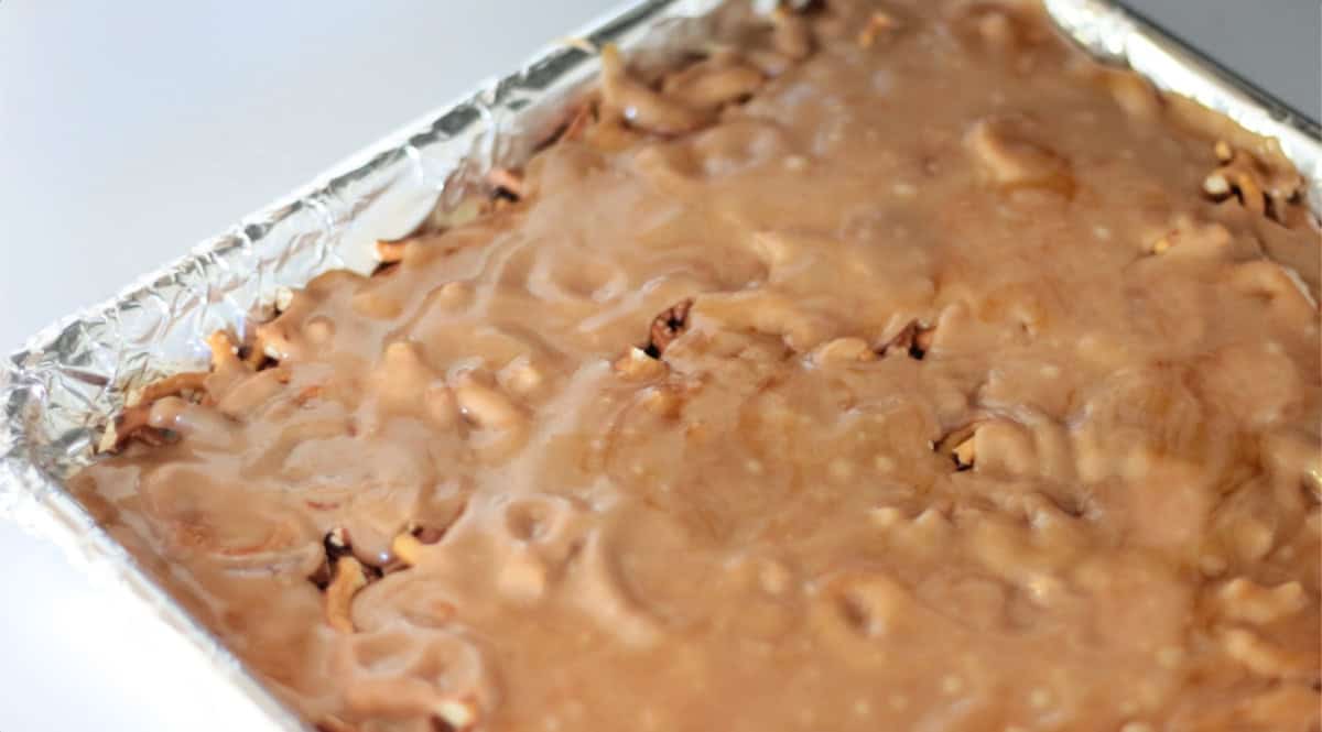 Baking sheet of chopped pretzels covered with hot toffee.