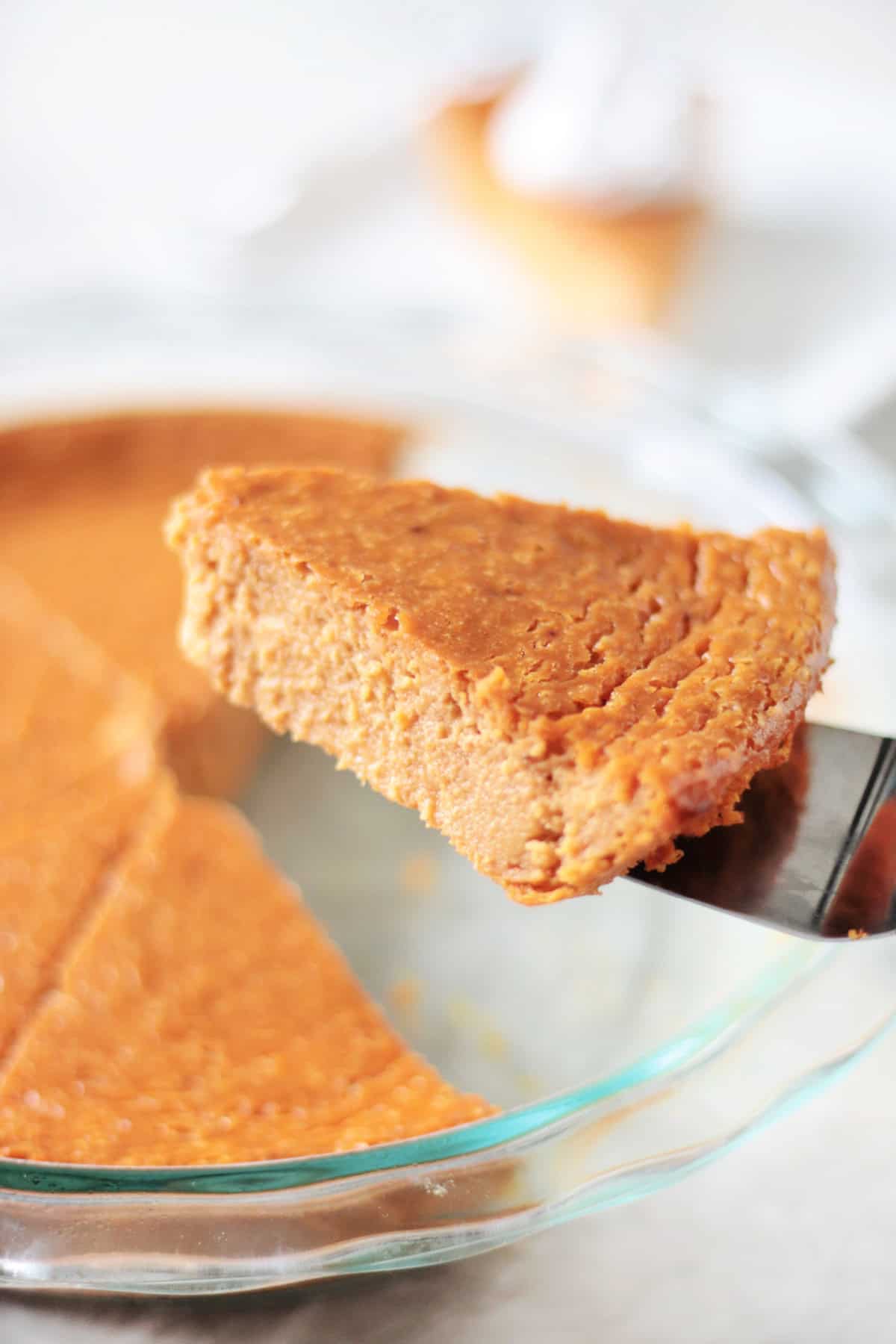 Slice of impossible pumpkin pie on metal spatula.