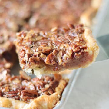 Slice of pecan slab pie on spatula.