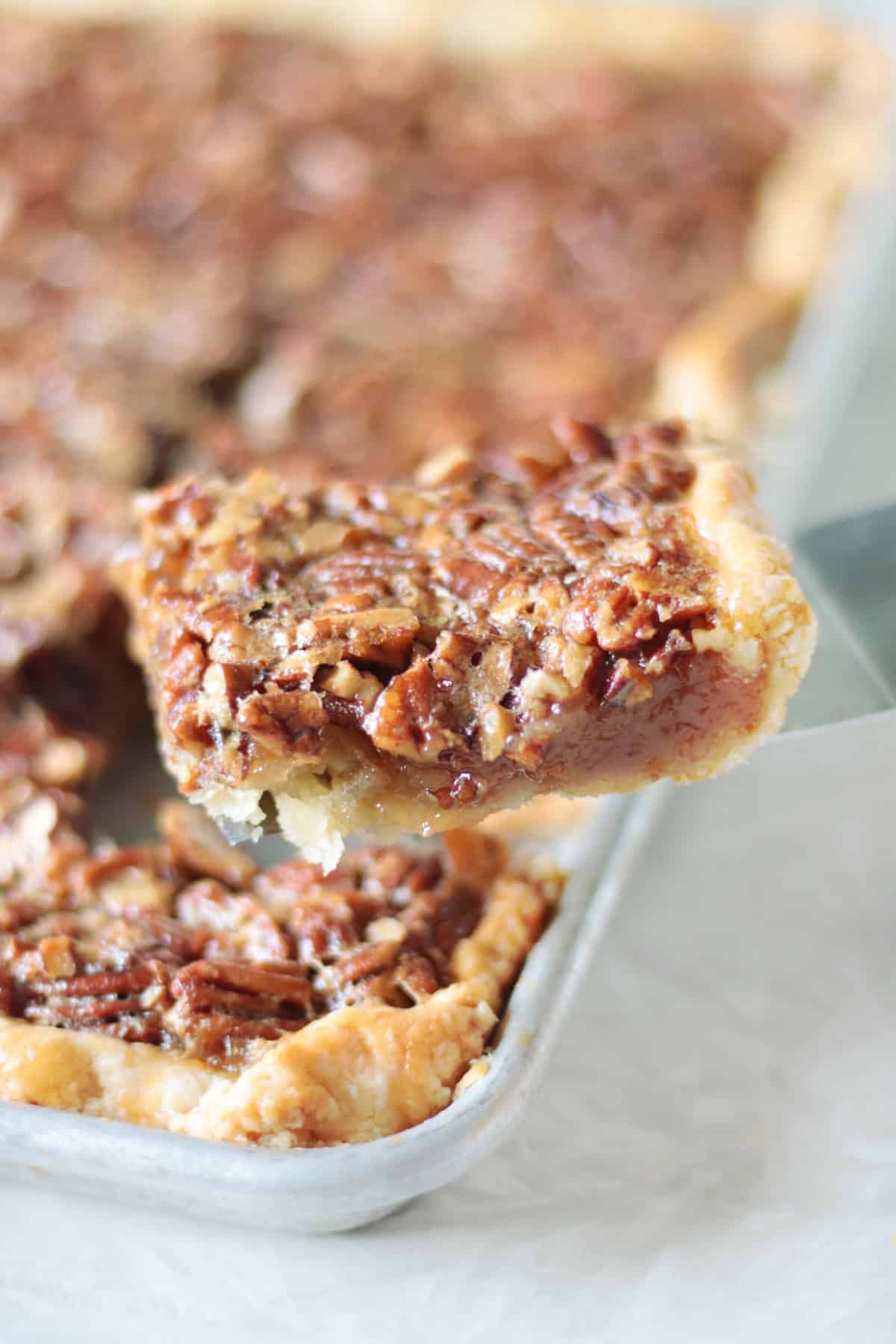 Slice of pecan slab pie on spatula.