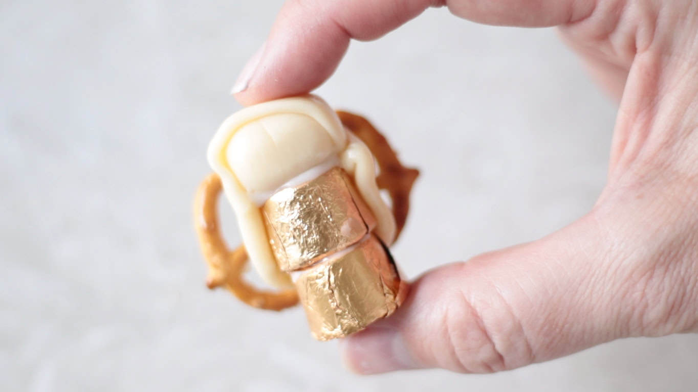 Hand holding an angel made from Tootsie Rolls, Rolos and pretzels.